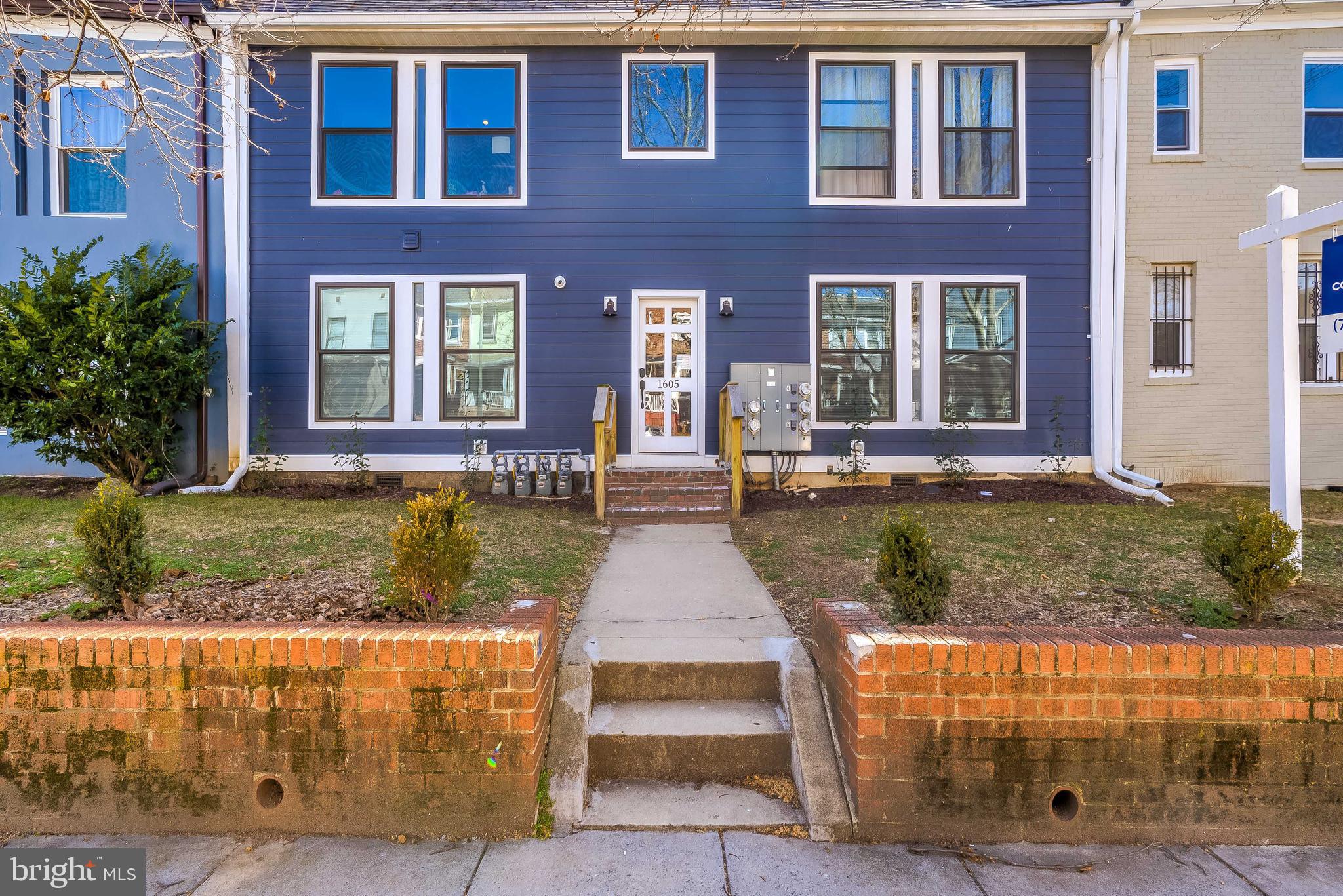 front view of a brick house with a yard