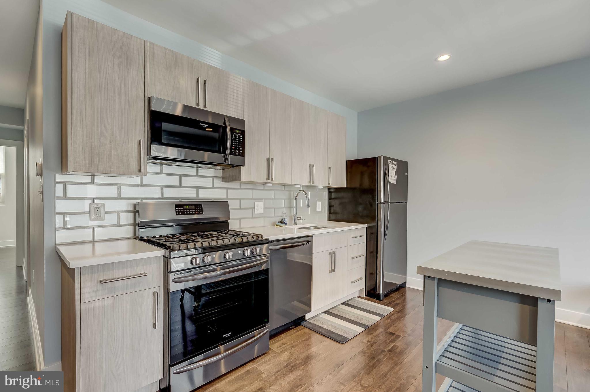 1605 F Street Northeast, Unit 2 Washington, DC 20002 - Photo 6 of 29 a kitchen with stainless steel appliances a stove a microwave and sink
