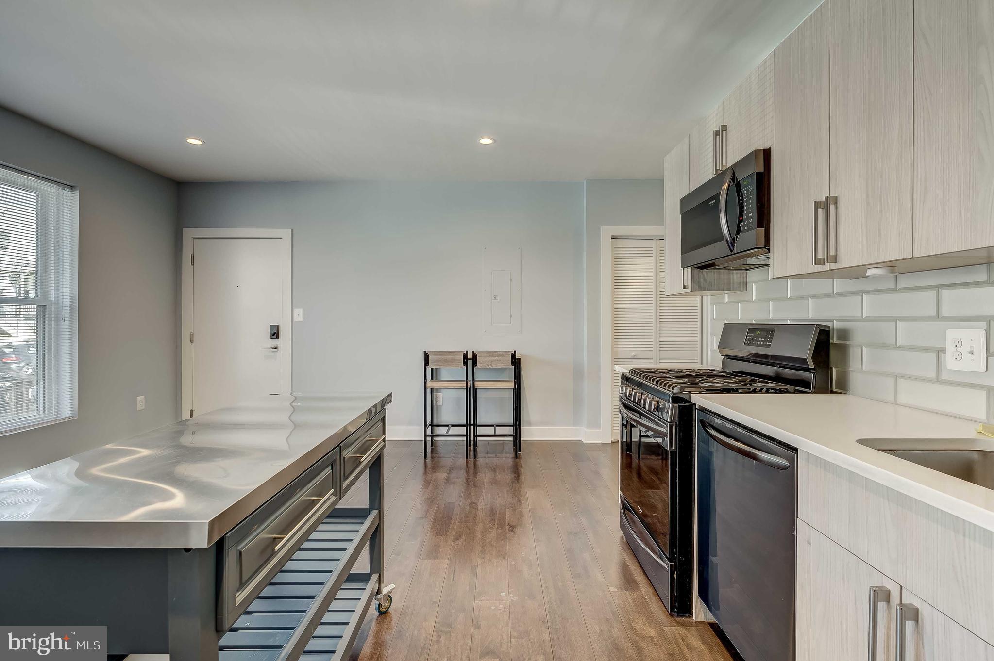 1605 F Street Northeast, Unit 2 Washington, DC 20002 - Photo 8 of 29 a kitchen with stainless steel appliances granite countertop a stove and a sink