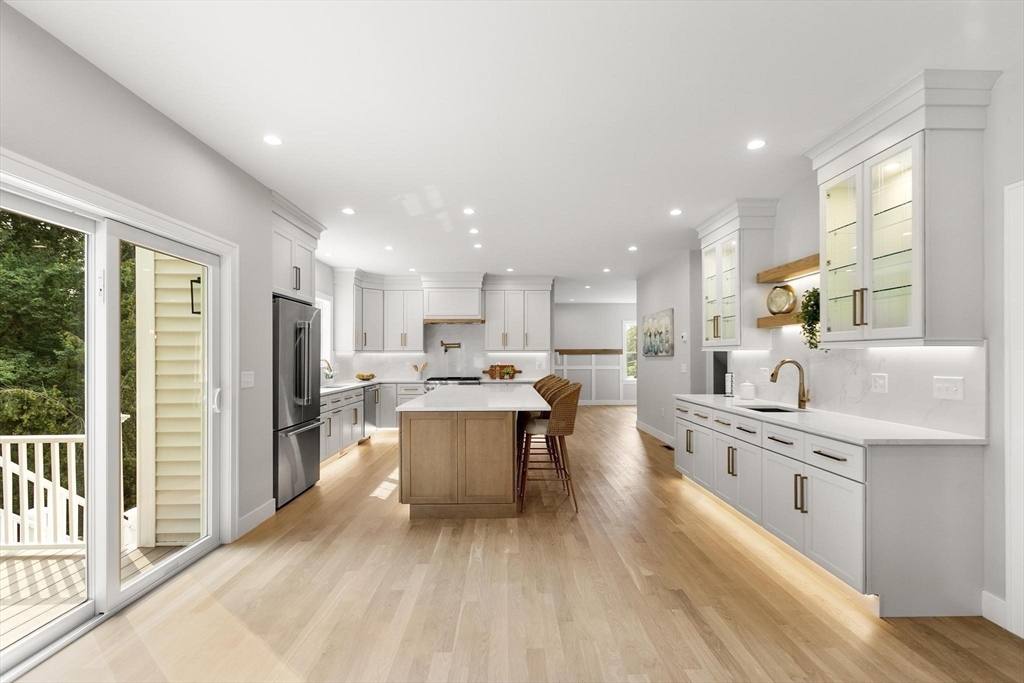 29 Beaverbrook Road Burlington, MA 01803 - Photo 12 of 42 a large white kitchen with stainless steel appliances kitchen island a large counter top and a view of living room