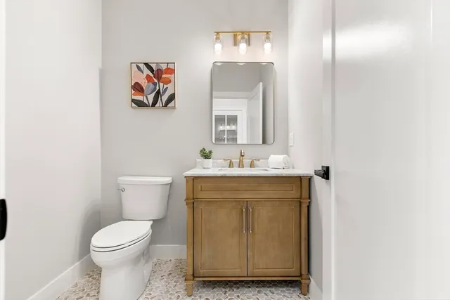 a bathroom with a toilet sink and mirror