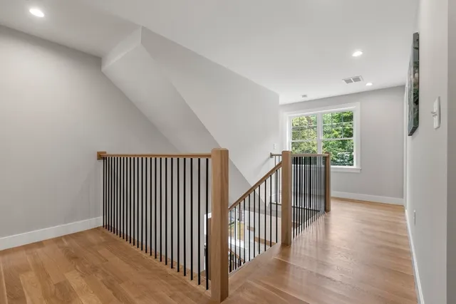 a view of a hallway with wooden floor and windows