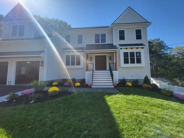 a view of a yard in front of a house with plants and large tree