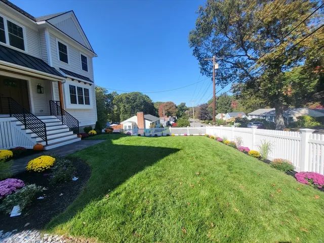 a view of a house with backyard and sitting area