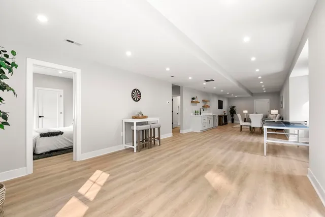 a view of a living room a dining room wooden floor and a window