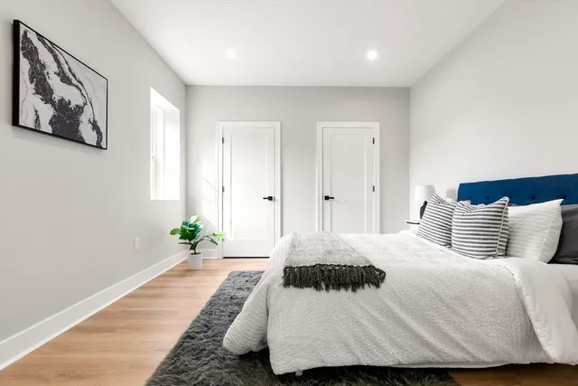 a bedroom with a large bed and a potted plant