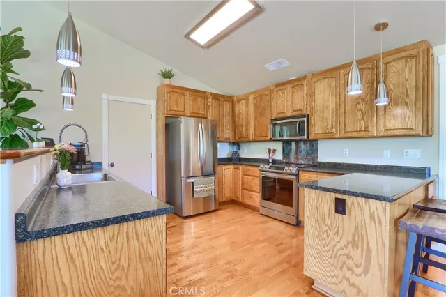 a kitchen with granite countertop cabinets stainless steel appliances and a counter space