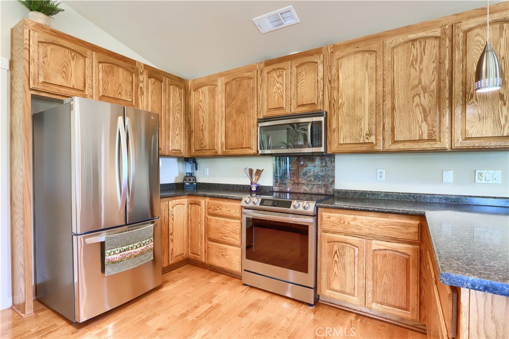 6097 Sherlock Road Midpines, CA 95345 - Photo 14 of 63 a kitchen with granite countertop a refrigerator stove and cabinets