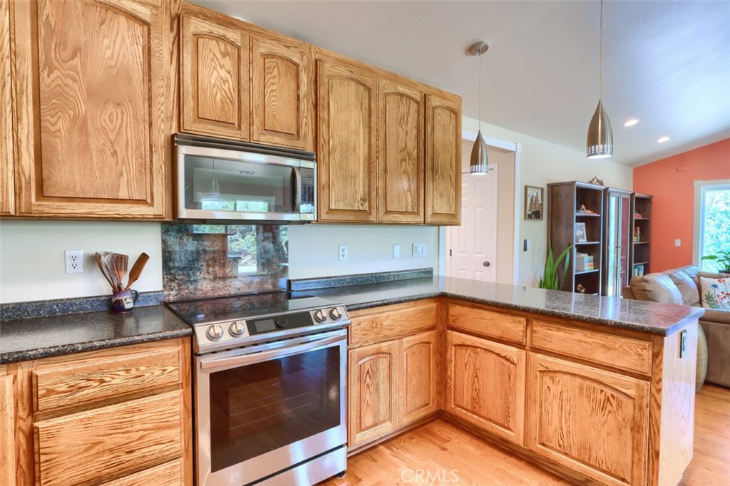 6097 Sherlock Road Midpines, CA 95345 - Photo 15 of 63 a kitchen with granite countertop cabinets stainless steel appliances and a counter space