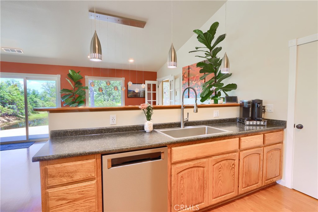 6097 Sherlock Road Midpines, CA 95345 - Photo 16 of 63 a kitchen with stainless steel appliances granite countertop a sink a counter space and a large window