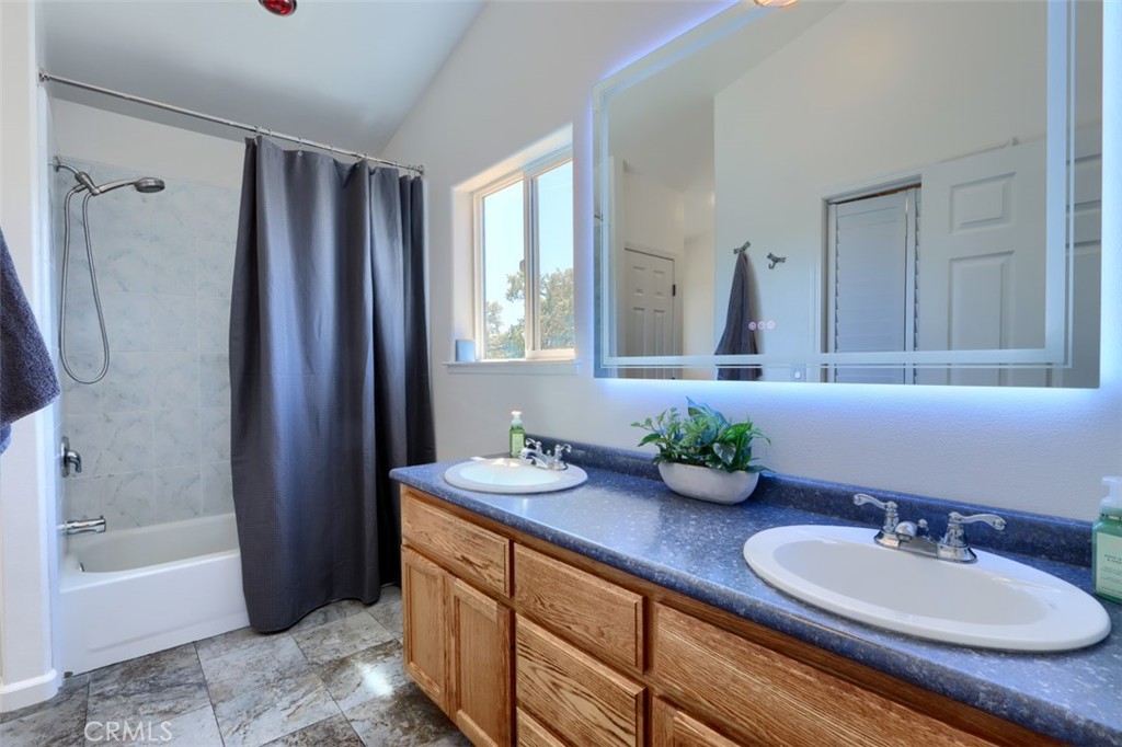 6097 Sherlock Road Midpines, CA 95345 - Photo 30 of 63 a bathroom with double vanity sinks a mirror and a bathtub