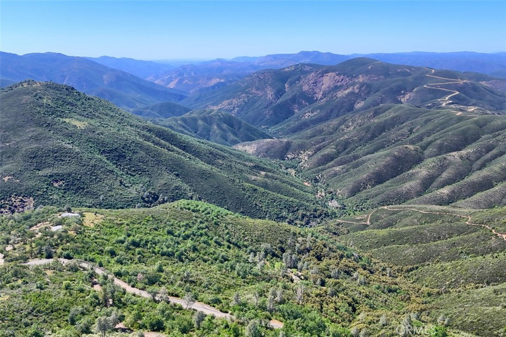6097 Sherlock Road Midpines, CA 95345 - Photo 58 of 63 a view of a lush green hillside and a houses