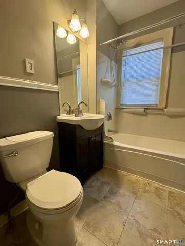 a bathroom with a toilet a sink and bathtub