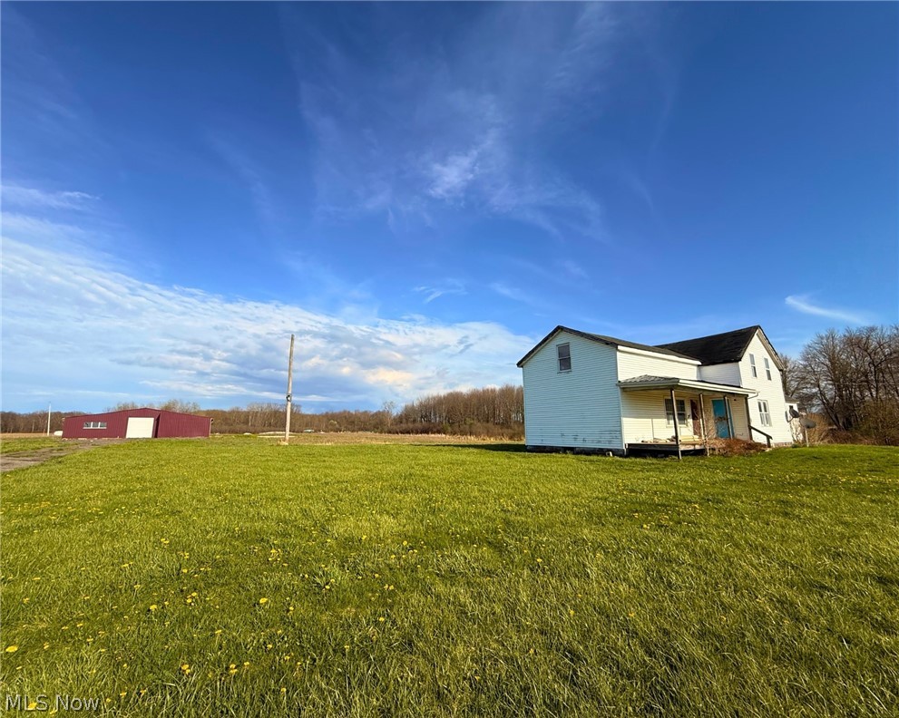 4772 Highway 45 Rome, OH 44085 - Photo 28 of 38 Expansive green acreage featuring a white traditional two-story dwelling with a covered porch and a dark shingle roof