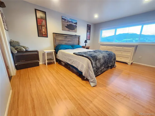 a spacious bedroom with a bed and a dresser