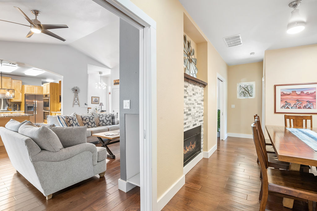 13326 Trautwein Road Austin, TX 78737 - Photo 15 of 38 Living area with a ceiling fan, dark wood-type flooring, a glass covered fireplace, vaulted ceiling, and baseboards