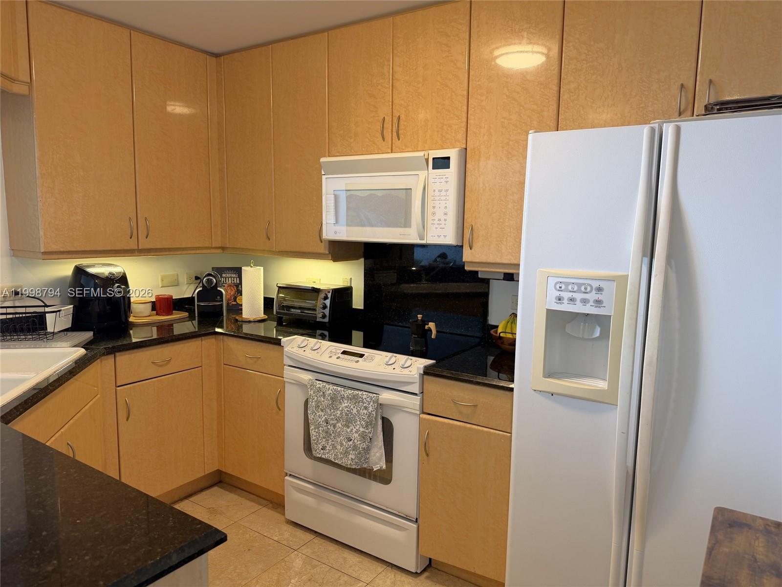 801 Brickell Key Boulevard, Unit 3207 Miami, FL 33131 - Photo 24 of 67 a kitchen with a refrigerator sink and cabinets