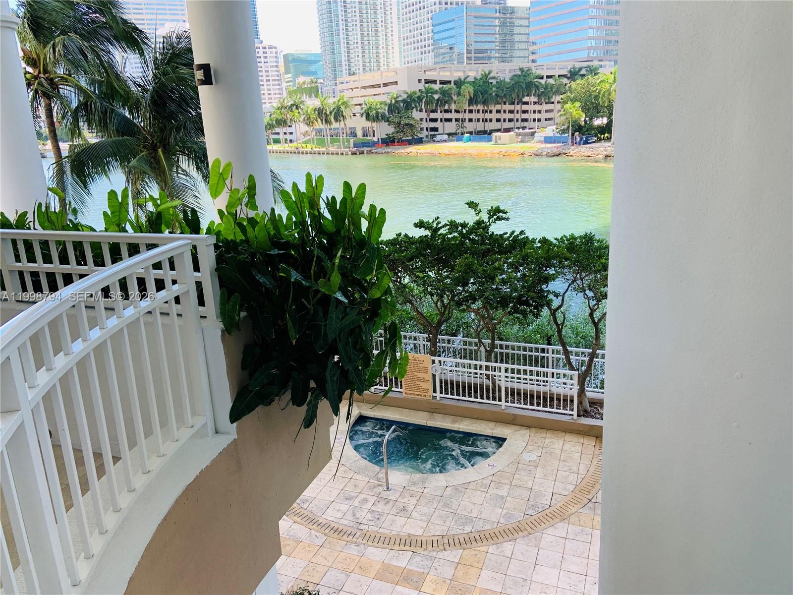 801 Brickell Key Boulevard, Unit 3207 Miami, FL 33131 - Photo 37 of 67 a small pool with a table and chair and wooden floor