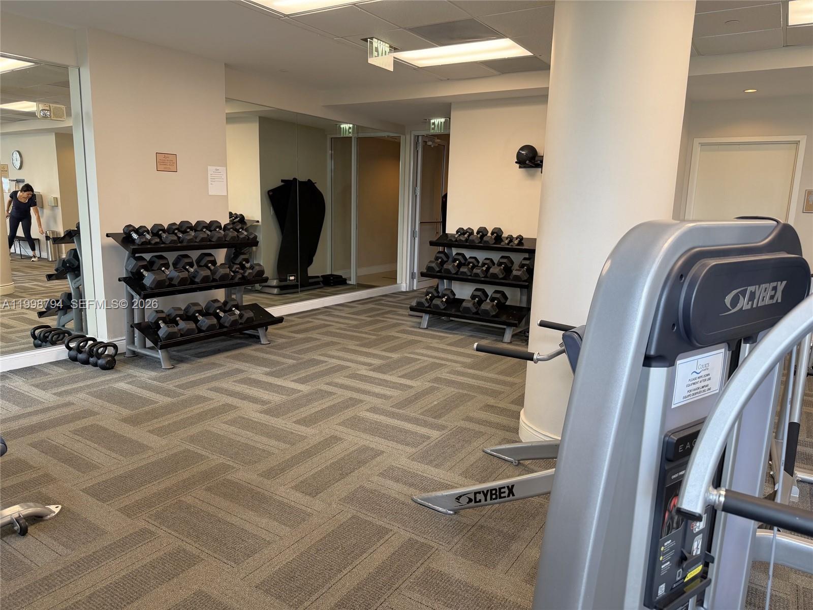 801 Brickell Key Boulevard, Unit 3207 Miami, FL 33131 - Photo 49 of 67 a room with gym equipment and a mirror