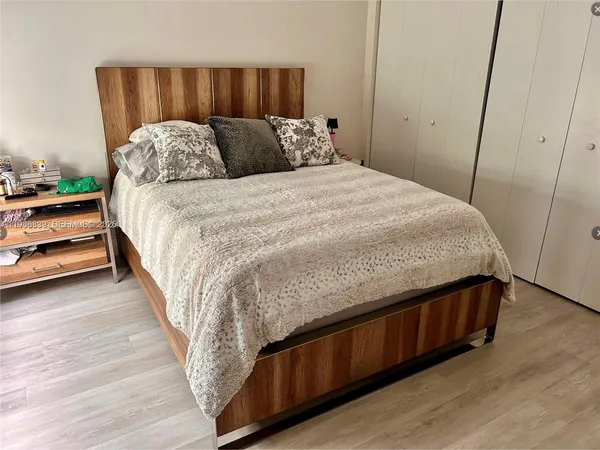 a large bed sitting in a bedroom next to a window