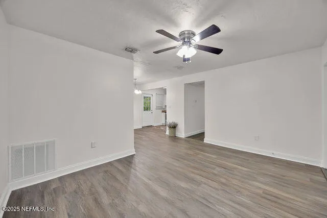 an empty room with a window and a fan