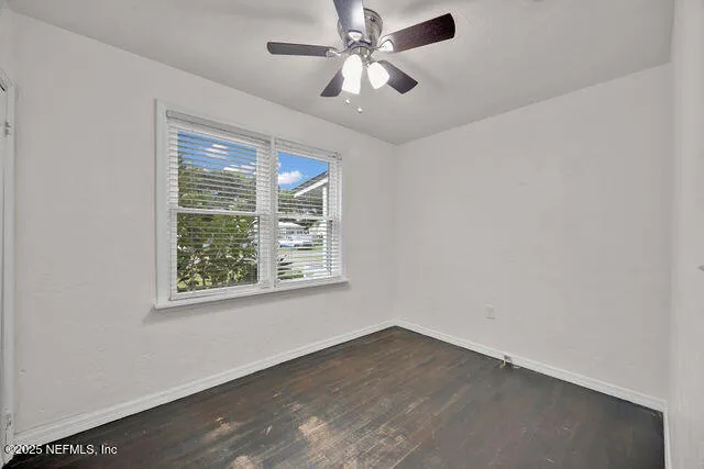 an empty room with a ceiling fan and closet area