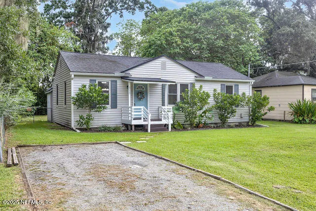 a front view of a house with a yard and trees