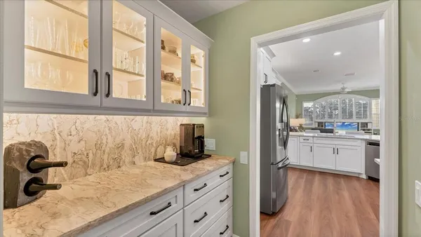 a kitchen with white cabinets and wooden floor