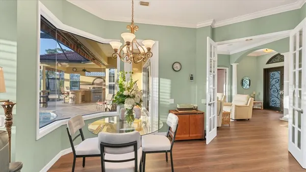 a view of a dining room with furniture wooden floor and chandelier