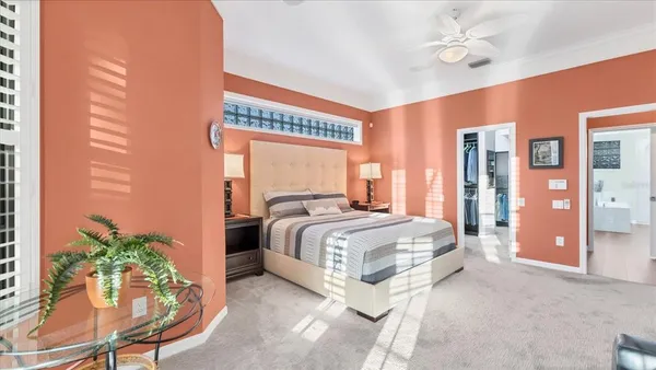 a bed sitting in a spacious bedroom next to a window