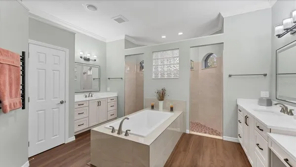 a spacious bathroom with a tub sink and mirror