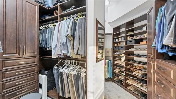 a view of walk in closet with clothes and shoes
