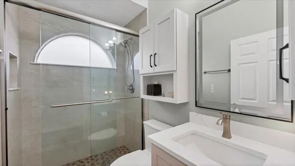 a bathroom with a sink a toilet and a mirror