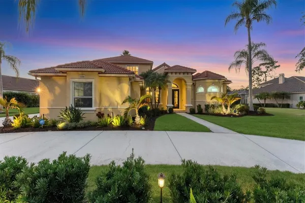 a front view of a house with a garden and trees