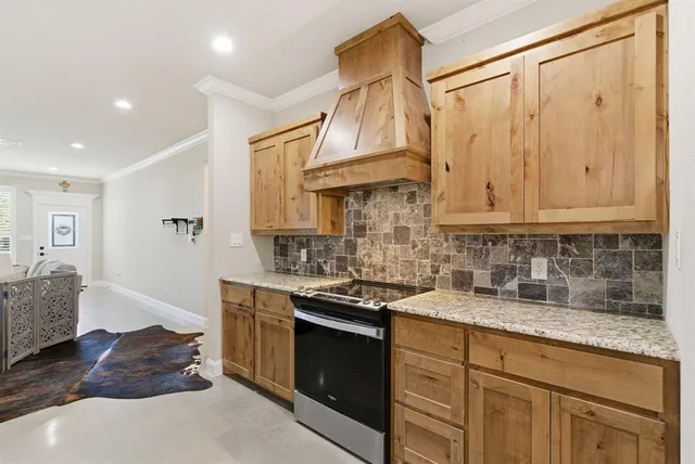 a kitchen with stainless steel appliances granite countertop a sink a stove and cabinets