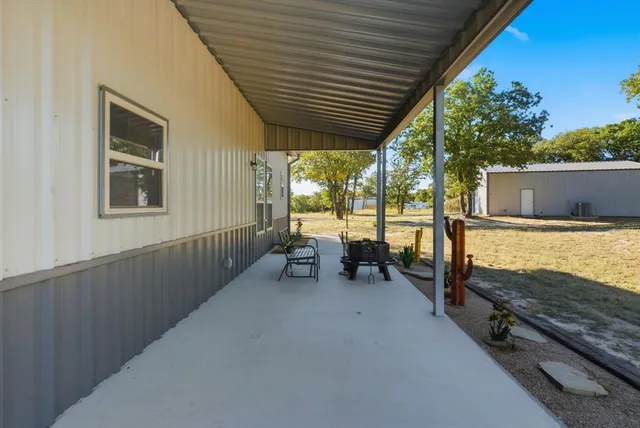 a view of a patio with wooden floor and roof with a barbeque grill