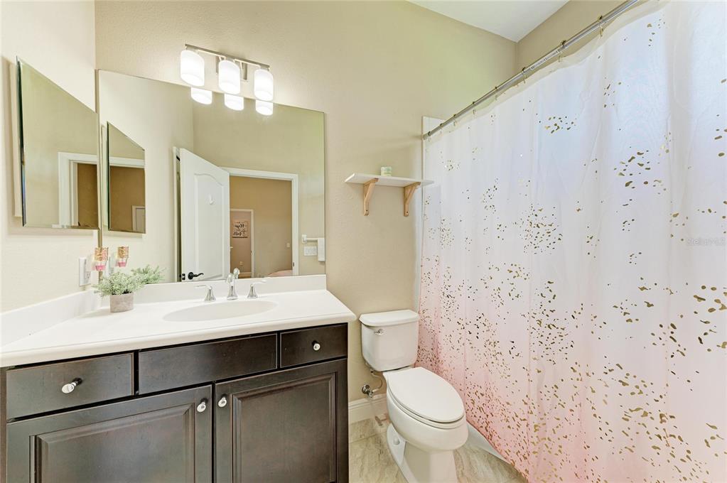 12642 Harney Street Venice, FL 34293 - Photo 33 of 85 a bathroom with a sink toilet vanity and shower