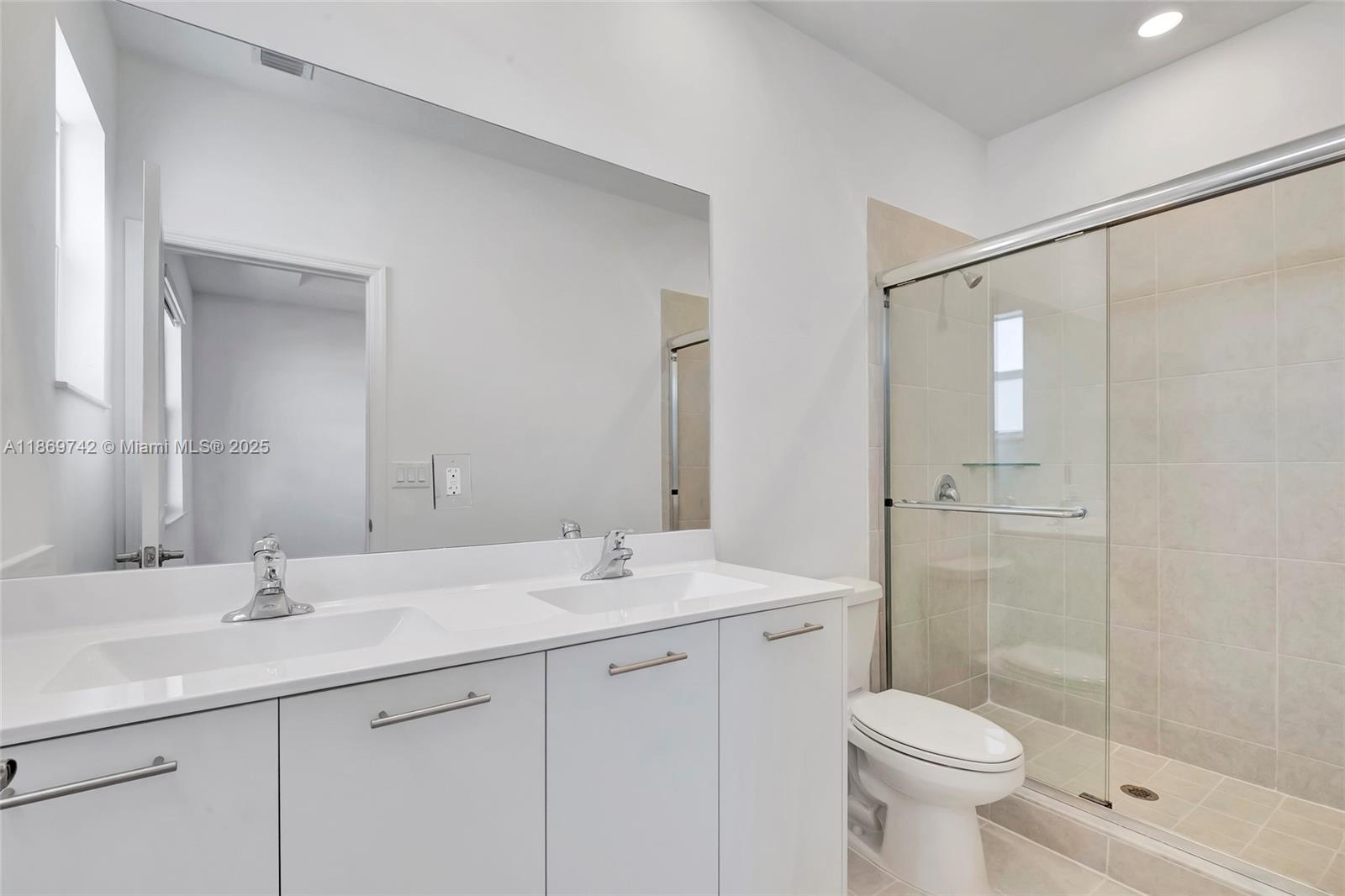 12206 Northwest 23rd Avenue Miami, FL 33167 - Photo 20 of 25 a bathroom with a double vanity sink toilet and shower