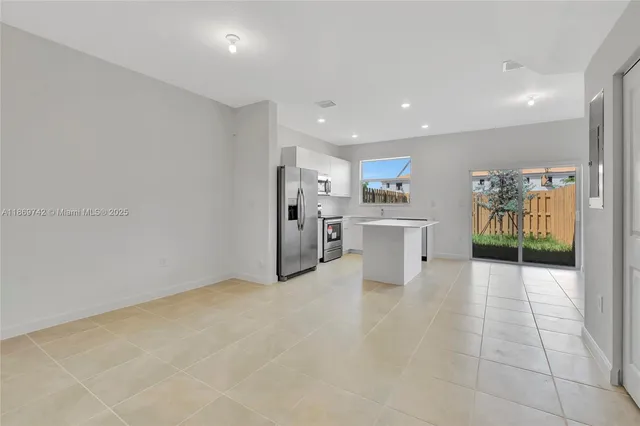 a view of a kitchen with refrigerator and furniture