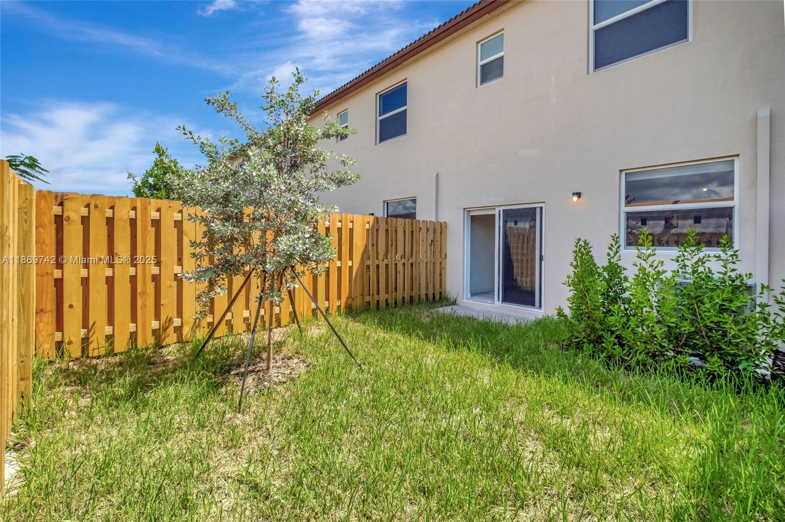 12206 Northwest 23rd Avenue Miami, FL 33167 - Photo 24 of 25 a view of backyard with potted plants and wooden fence