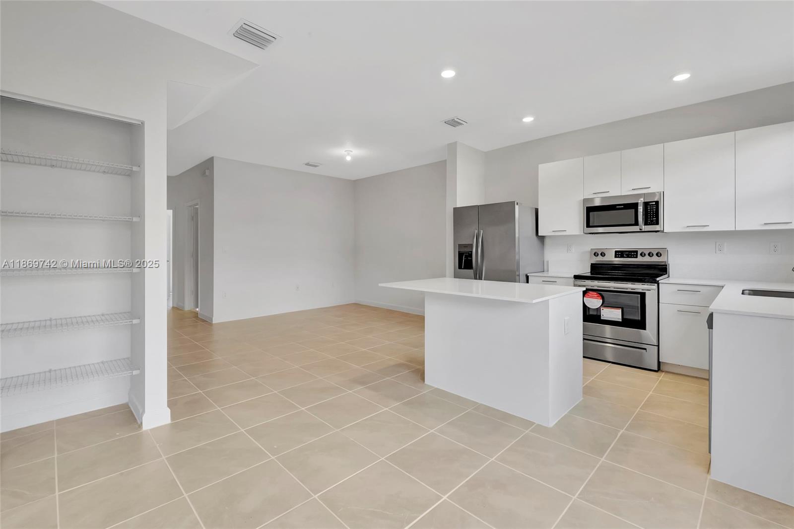 12206 Northwest 23rd Avenue Miami, FL 33167 - Photo 4 of 25 a kitchen with stainless steel appliances a refrigerator sink and microwave