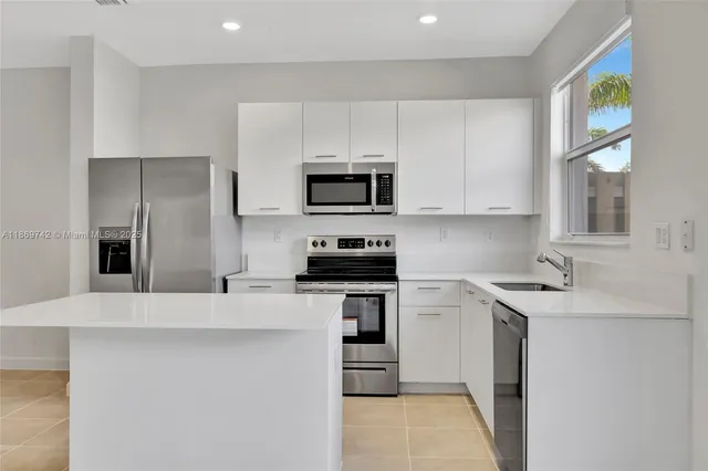 a kitchen with stainless steel appliances a stove a sink a microwave and cabinets