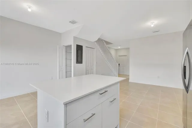 a kitchen with a wooden floor and white cabinets
