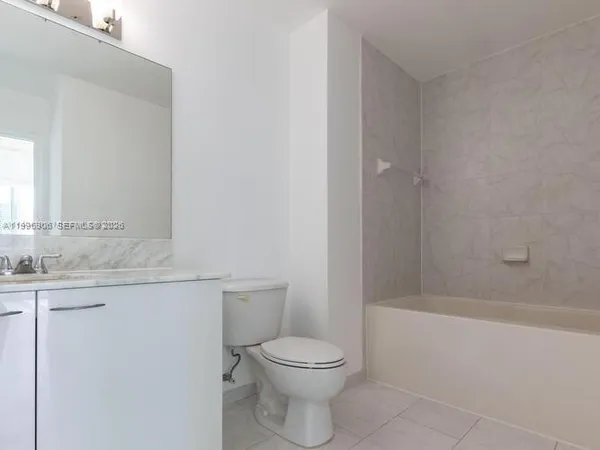 a bathroom with a granite countertop toilet a sink and a bathtub