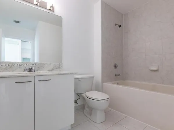a bathroom with a granite countertop toilet a sink and bathtub