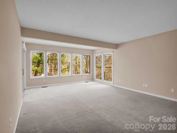 a view of a porch with wooden floor and floor to ceiling window