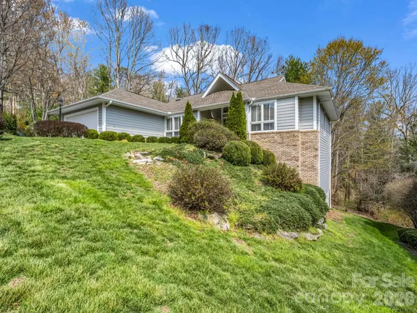 a backyard of a house with table and chairs under an umbrella