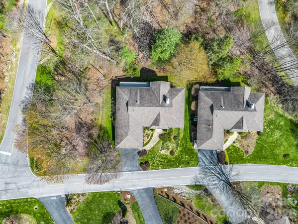 a view of a house with yard and trees in the background