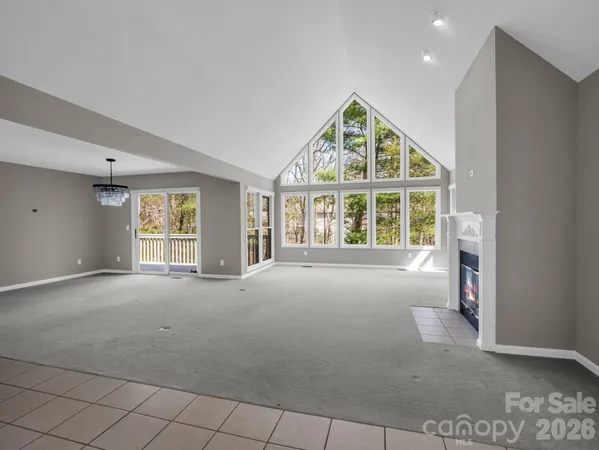 a view of an empty room with a fireplace and a window
