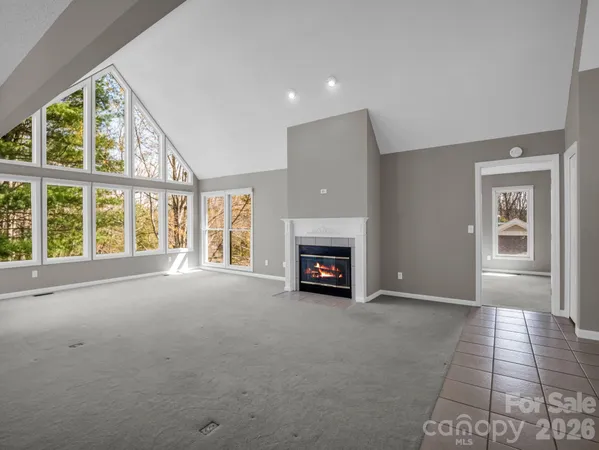 an empty room with fireplace and windows